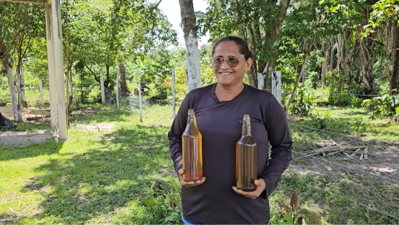 Maria Antônia Martins mostra duas garrafas de mel de sua produção. Foto: Cristiane Viana/Acervo ISPN